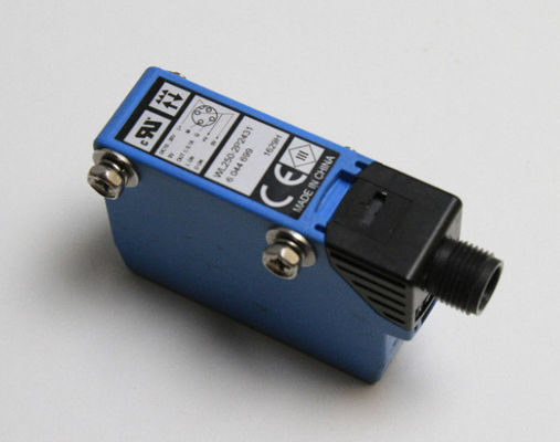 Kompaktowy czujnik fotoelektryczny SICK W250-2P2431 z widocznym czerwonym światłem i numerem części 6044699